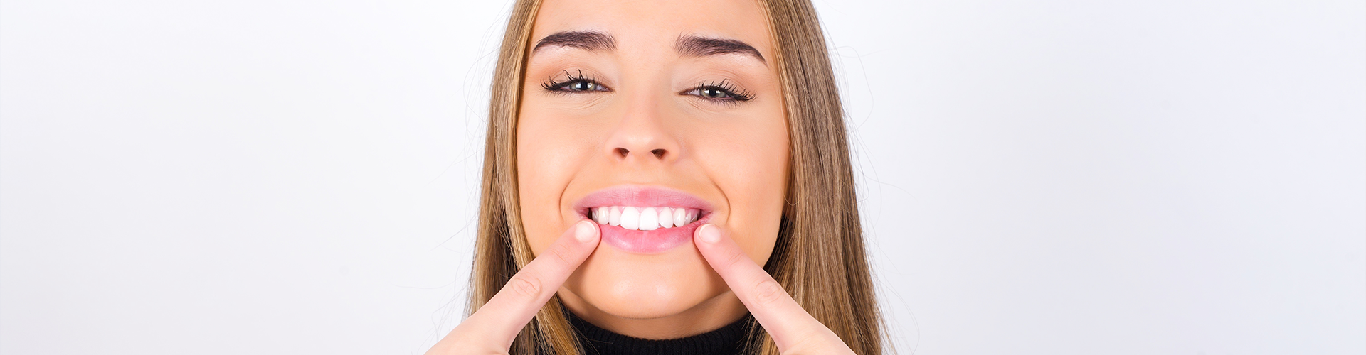 woman pointing to her smile.